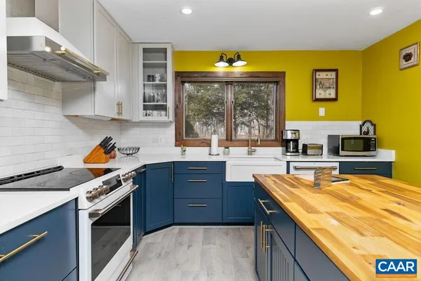 a kitchen with stainless steel appliances granite countertop a table chairs sink and cabinets