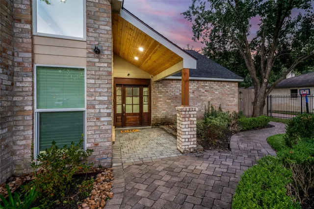 a view of a house with brick walls and potted plants