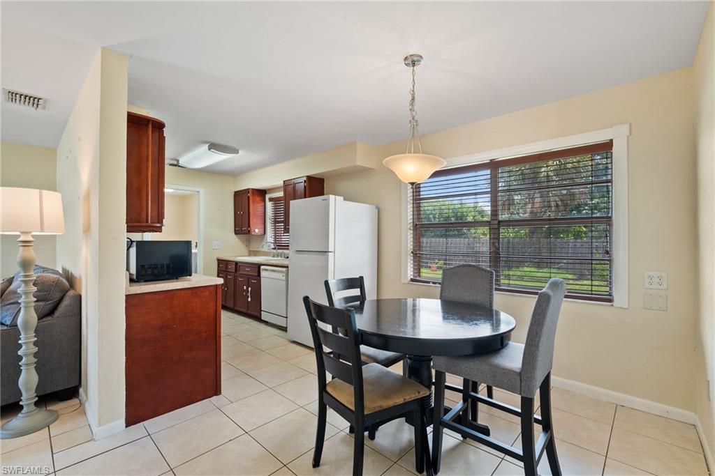 18565 Sebring Road Fort Myers, FL 33967 - Photo 8 of 23 a dining room with furniture a chandelier and wooden floor