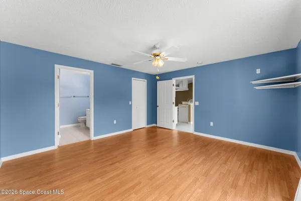 a view of an empty room with a chandelier fan