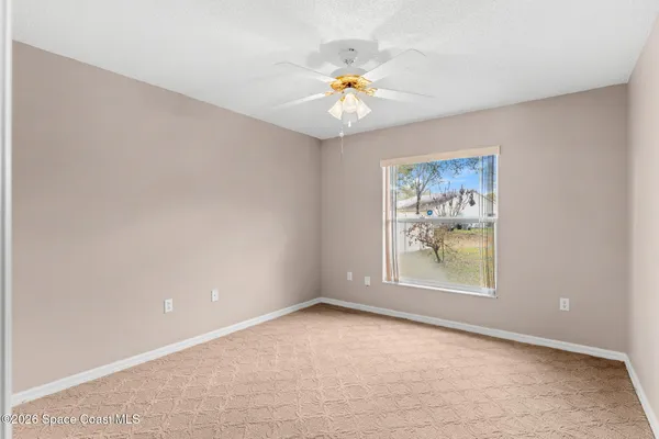 an empty room with a window and wooden floor