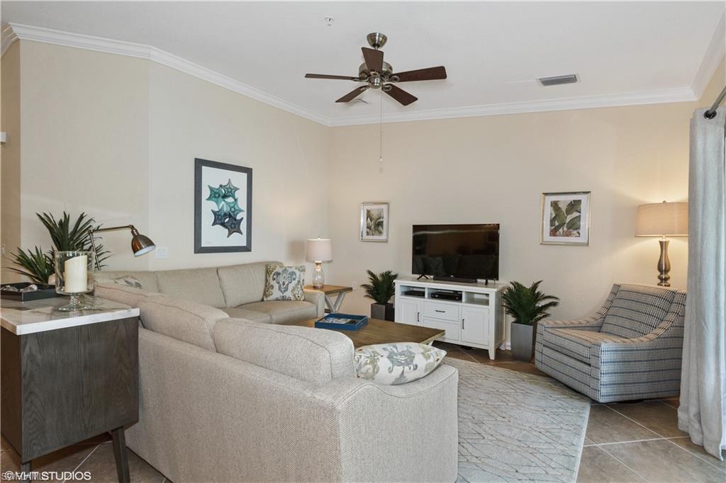 9529 Avellino Way, Unit 2823 Naples, FL 34113 - Photo 4 of 25 a living room with furniture and a flat screen tv