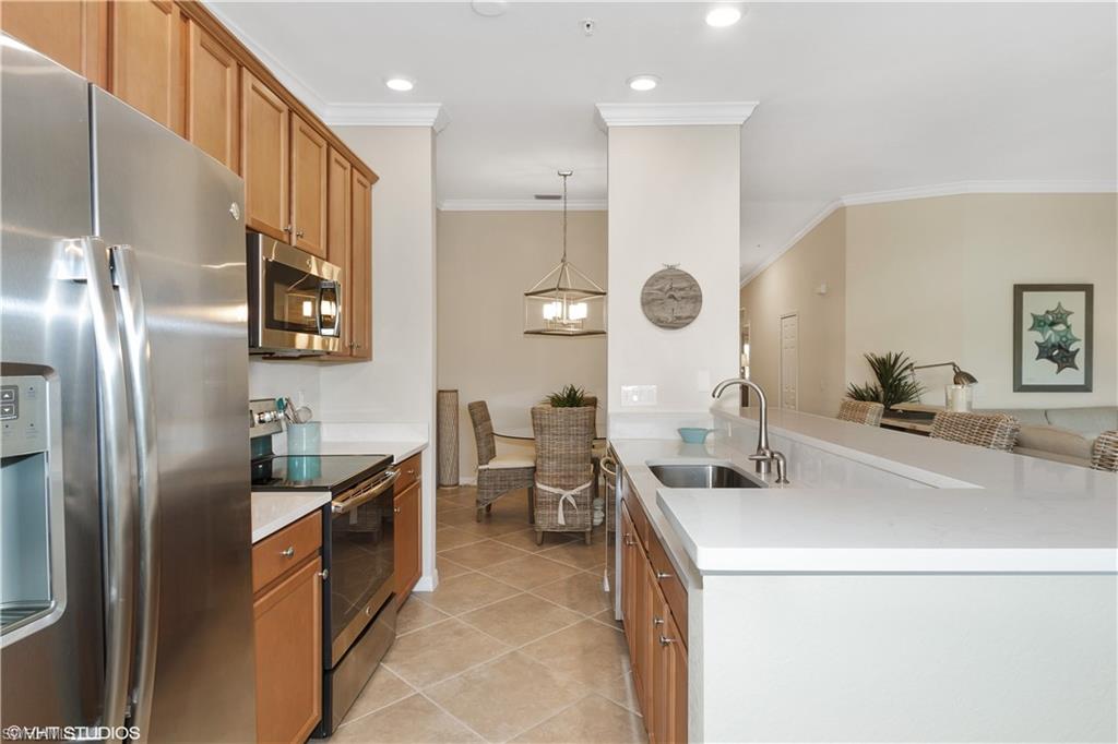 9529 Avellino Way, Unit 2823 Naples, FL 34113 - Photo 6 of 25 a kitchen with stainless steel appliances a refrigerator sink and stove