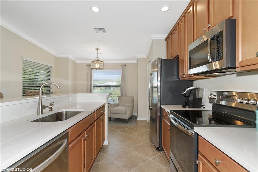 9529 Avellino Way, Unit 2823 Naples, FL 34113 - Photo 8 of 25 a kitchen with stainless steel appliances granite countertop a sink stove and refrigerator