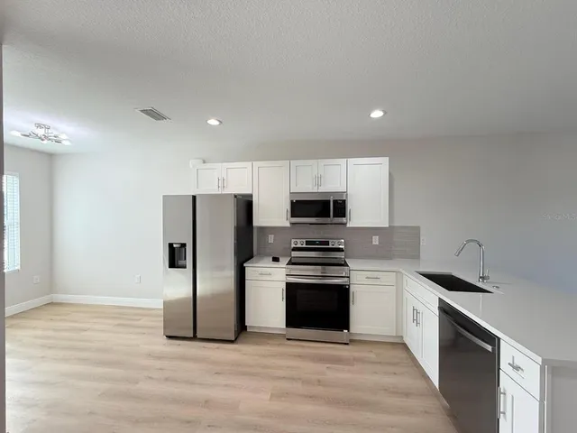 a kitchen with stainless steel appliances a stove a sink and a refrigerator