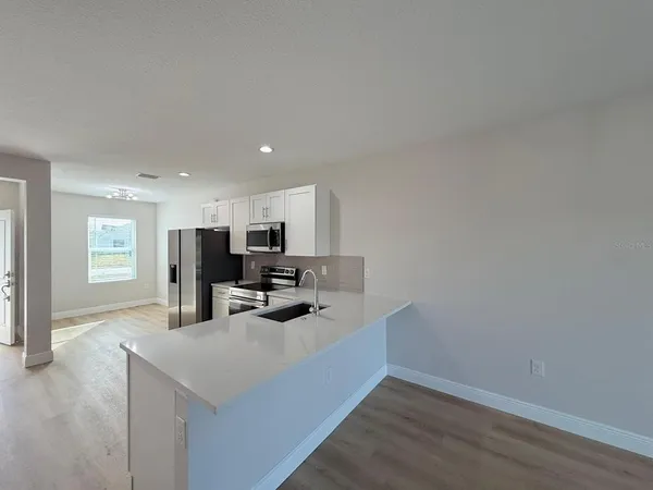 a view of kitchen with microwave stove and cabinets