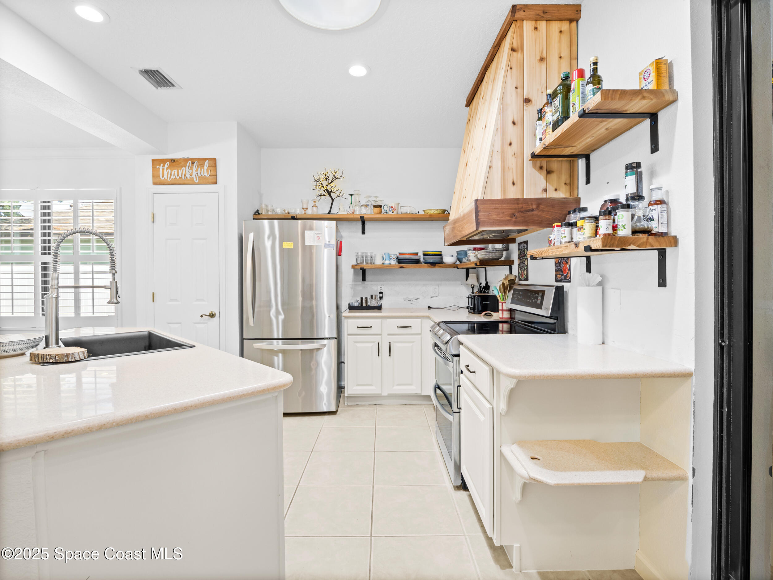 1214 Bolle Circle Rockledge, FL 32955 - Photo 13 of 27 a kitchen that has a lot of white cabinets and stainless steel appliances