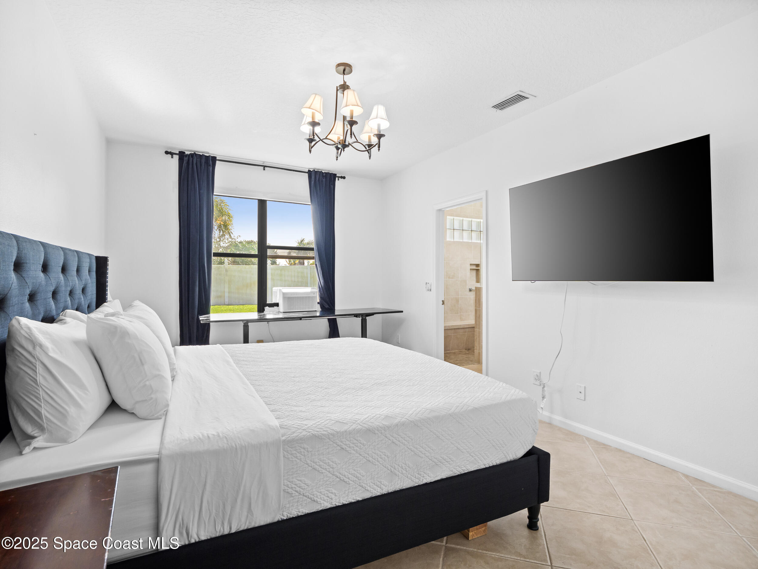 1214 Bolle Circle Rockledge, FL 32955 - Photo 16 of 27 a bedroom with a bed and a flat screen tv