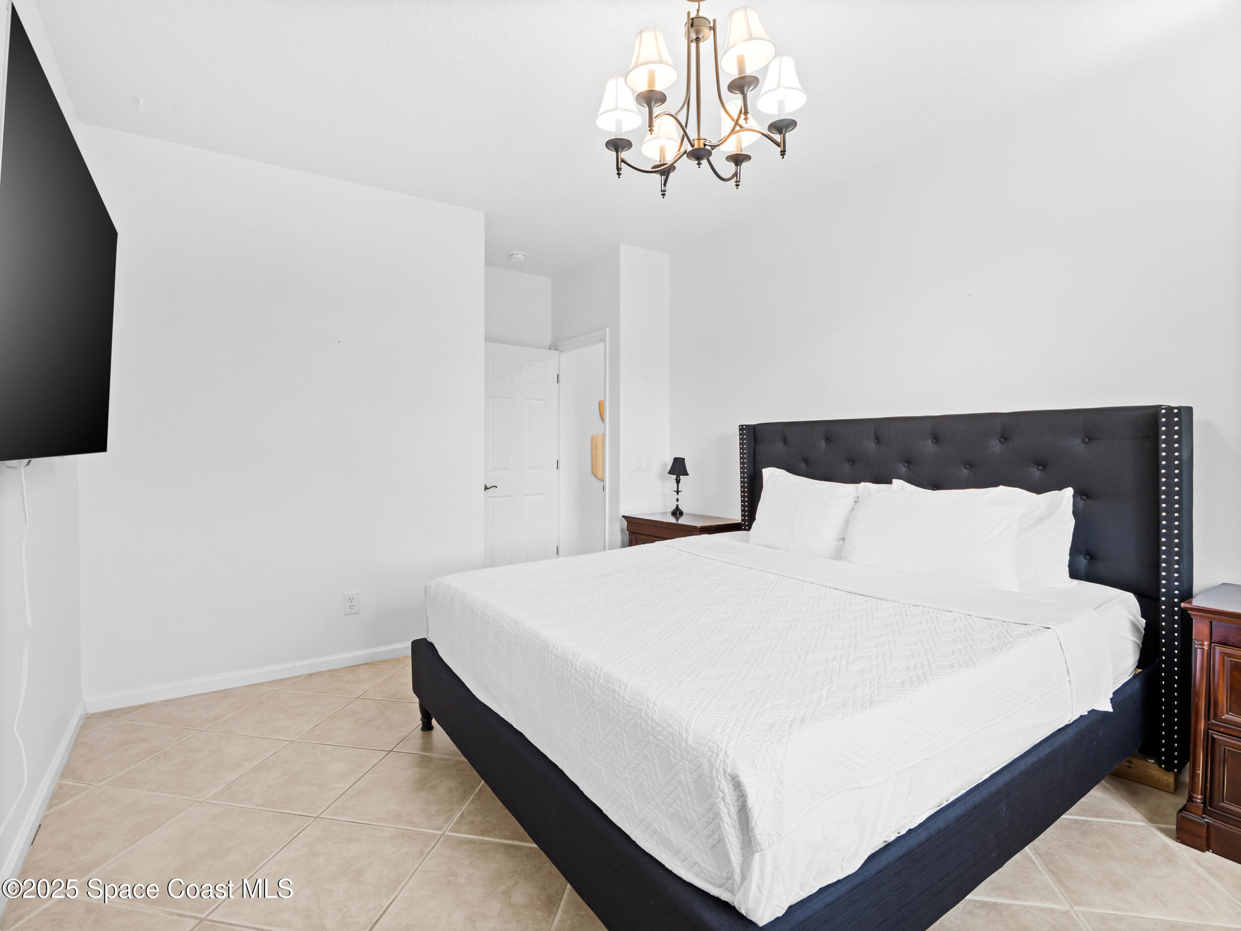 1214 Bolle Circle Rockledge, FL 32955 - Photo 17 of 27 a large bed sitting in a bedroom and a chandelier