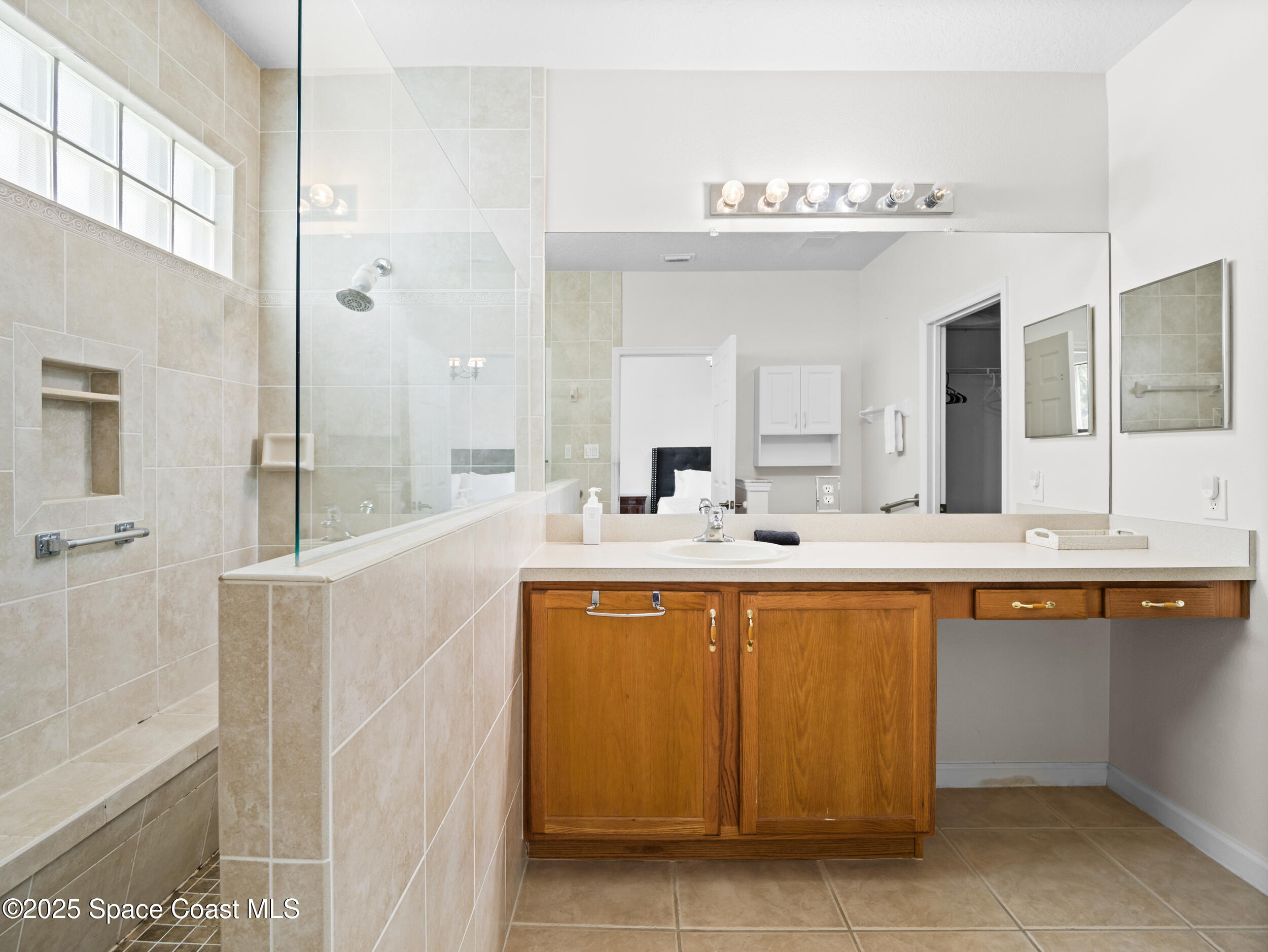 1214 Bolle Circle Rockledge, FL 32955 - Photo 18 of 27 a spacious bathroom with a granite countertop sink a mirror a bathtub and shower