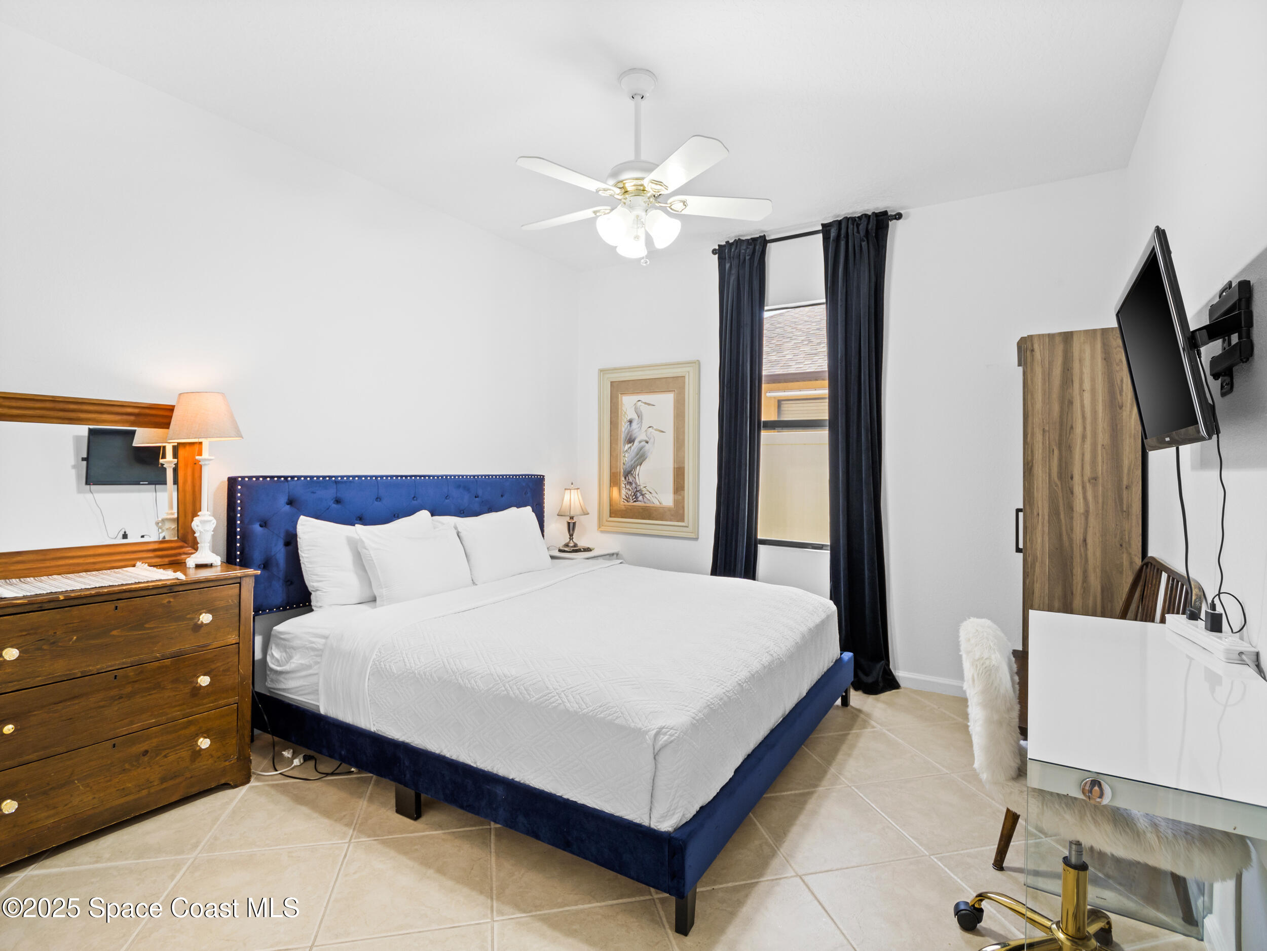 1214 Bolle Circle Rockledge, FL 32955 - Photo 21 of 27 a bedroom with a large bed and a flat tv screen on a dresser