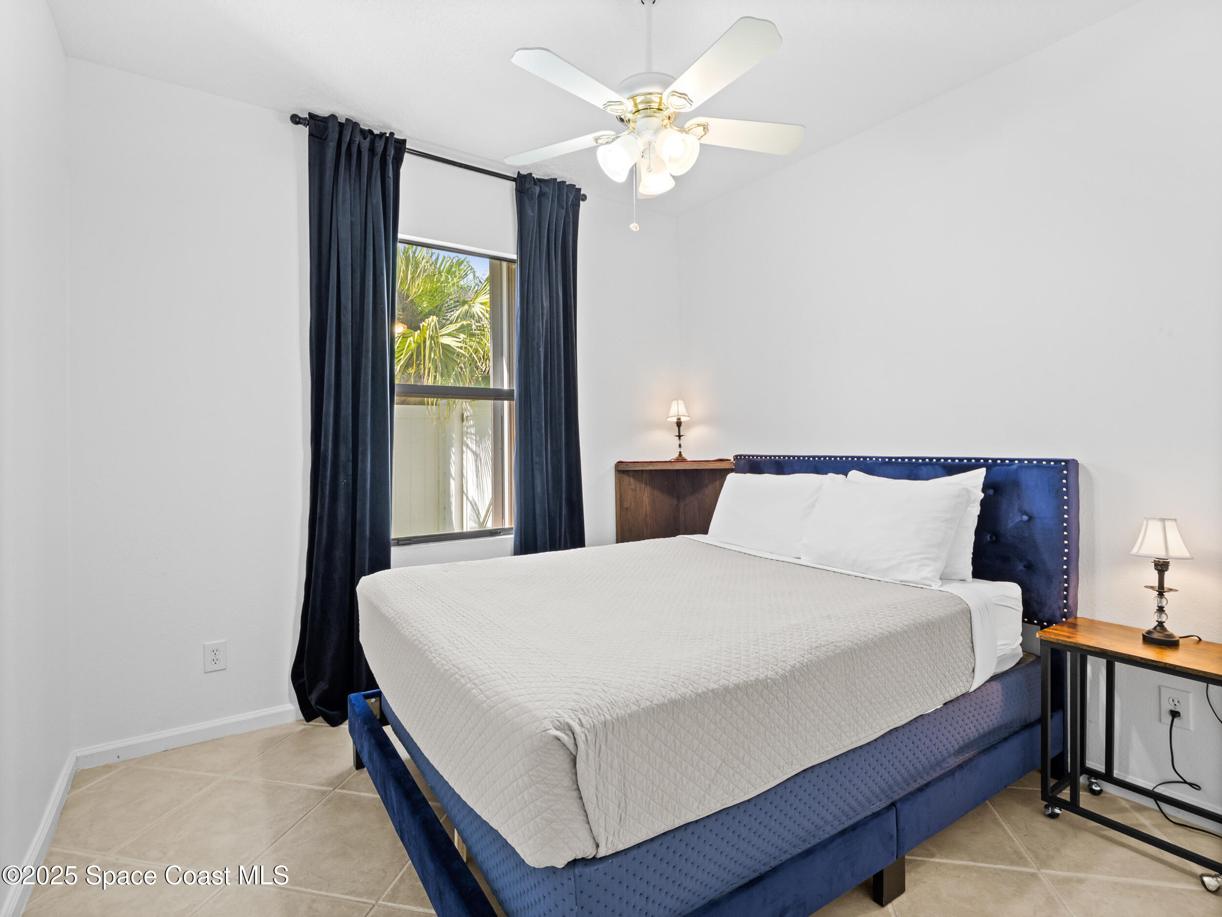 1214 Bolle Circle Rockledge, FL 32955 - Photo 22 of 27 a bedroom with a large bed and a chandelier