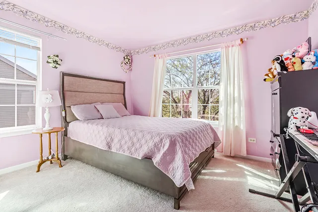 a bedroom with a bed a window and dresser