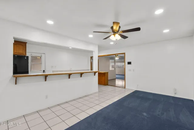 a view of a kitchen with wooden cabinet and a ceiling fan