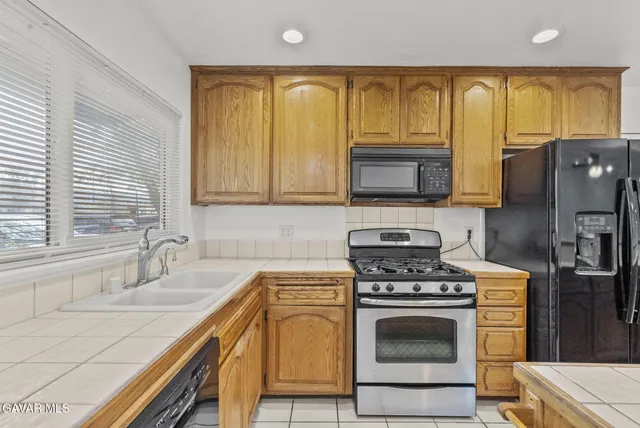 a kitchen with stainless steel appliances granite countertop a stove a sink and a microwave