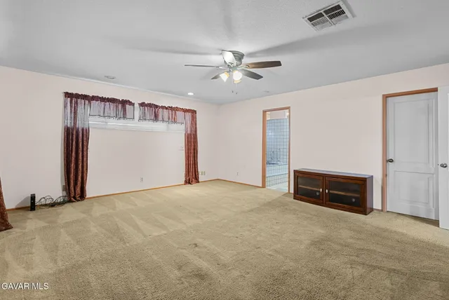 an empty room with closet and a ceiling fan