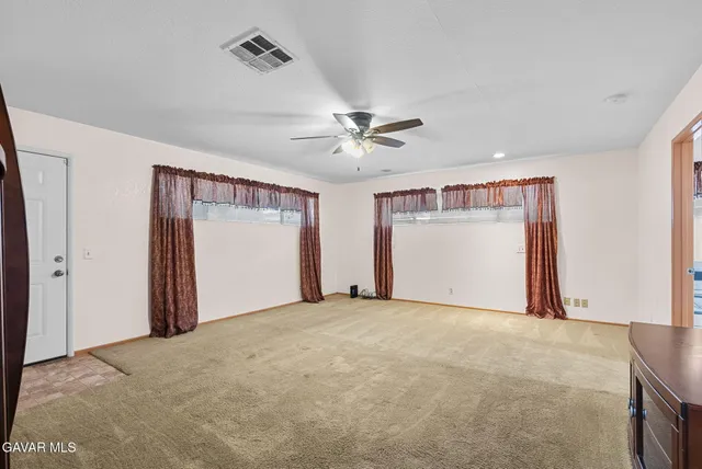 a view of a livingroom with a ceiling fan and window
