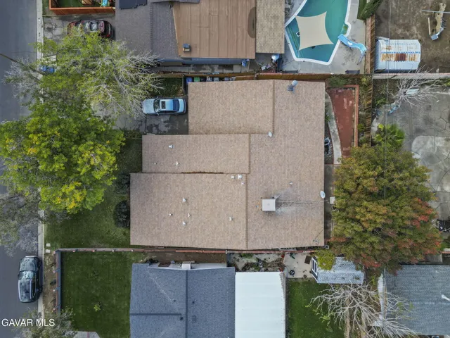 an aerial view of residential houses with outdoor space and parking
