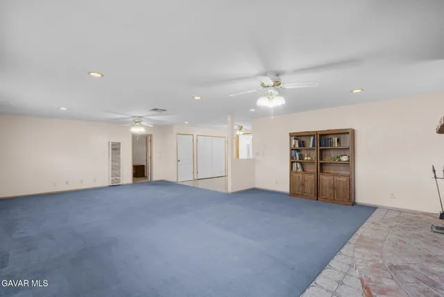 an empty room with closet and windows