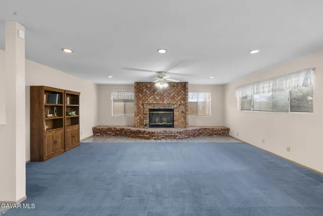 a view of an empty room with a fireplace and a window