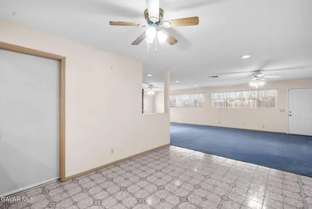 an empty room with fan and windows