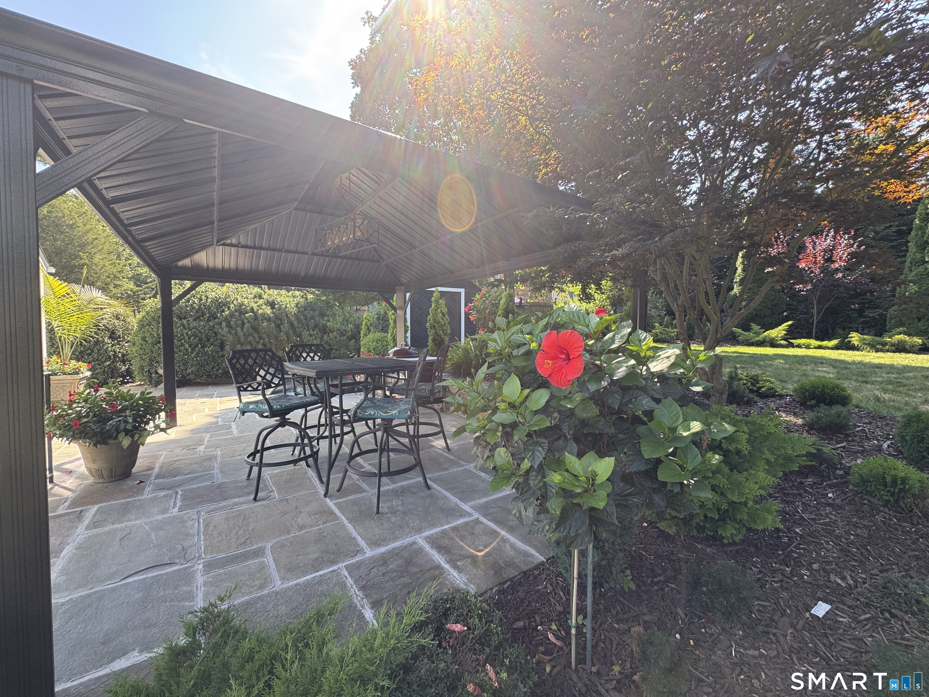 561 River Road Greenwich, CT 06870 - Photo 5 of 6 a view of a patio with a table and chairs and potted plants