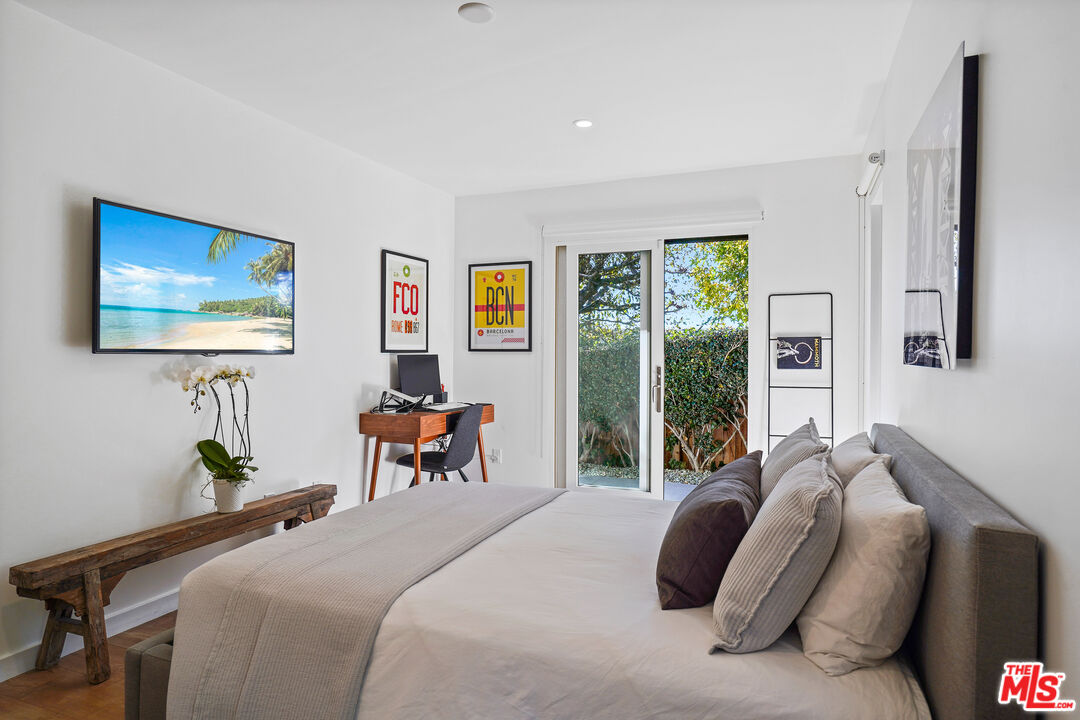 20413 Roca Chica Drive Malibu, CA 90265 - Photo 23 of 27 a bedroom with bed and glass window