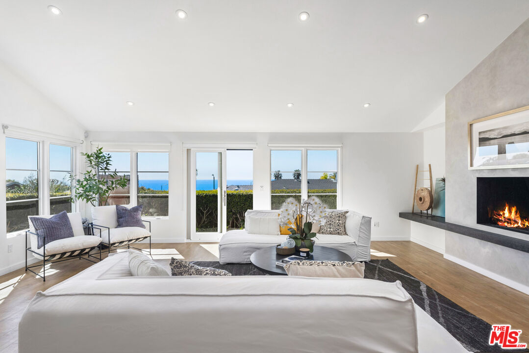 20413 Roca Chica Drive Malibu, CA 90265 - Photo 5 of 27 a living room with furniture large window and a fireplace