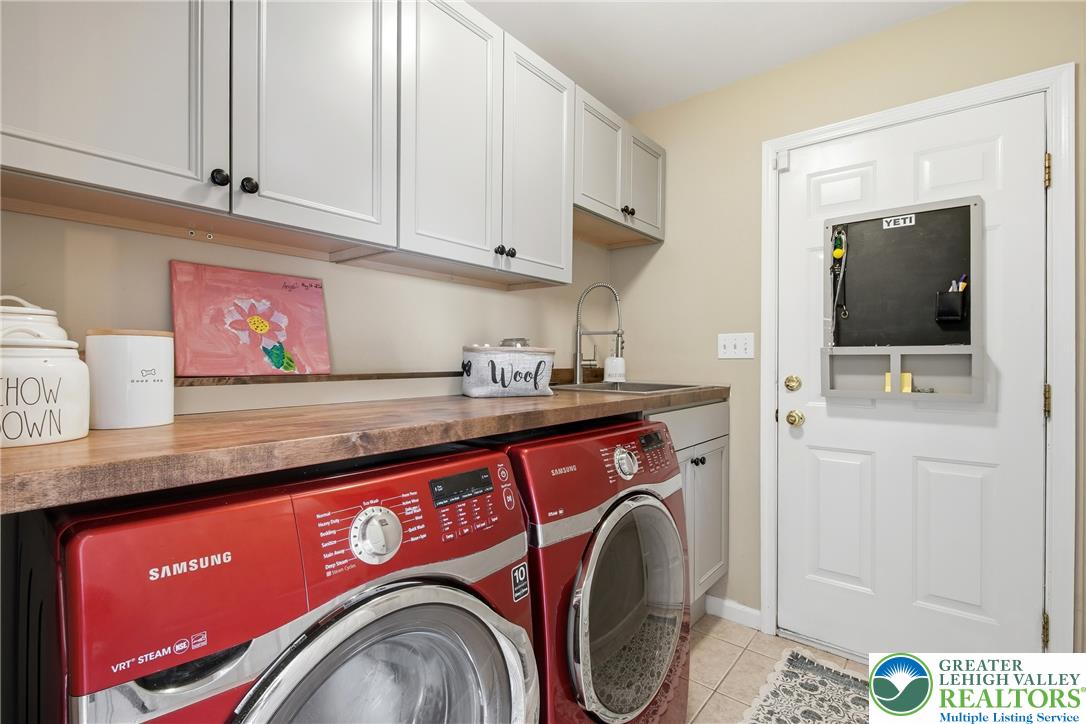 115 West Butternut Road Hellertown, PA 18055 - Photo 32 of 97 Functional laundry room featuring a utility sink and abundant cabinet storage.