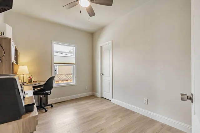 a view of a workspace with furniture and a window