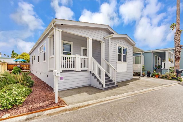 a view of a house with a small yard and wooden fence
