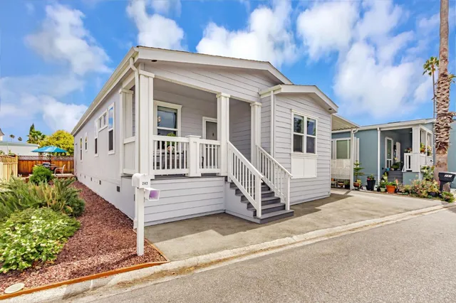 a view of a house with a small yard and wooden fence