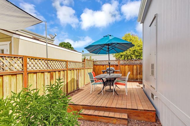 a view of a patio with furniture and table under an umbrella