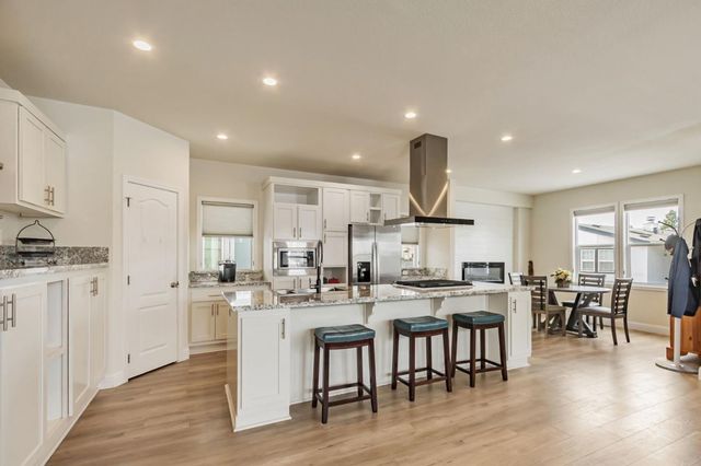 a kitchen with stainless steel appliances kitchen island granite countertop a sink and cabinets