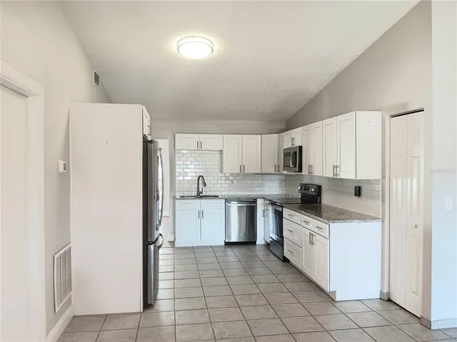 a kitchen with white cabinets and white appliances