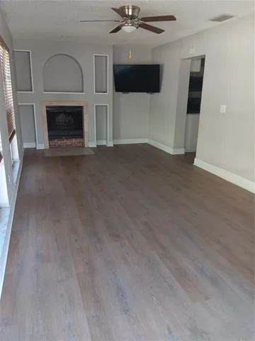 an empty room with fireplace and fan