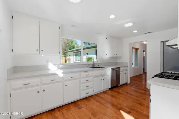a kitchen with granite countertop white cabinets and white appliances
