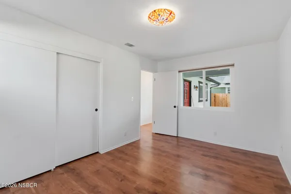 an empty room with a wooden floor and a window