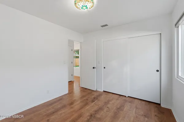 a view of an empty room with wooden floor