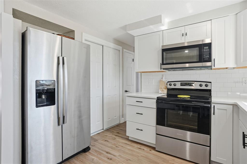 4750 Foothill Drive Holiday, FL 34690 - Photo 16 of 38 a kitchen with stainless steel appliances a stove a microwave and a refrigerator
