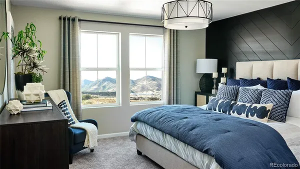 a bedroom with a bed mirror and painting on the wall