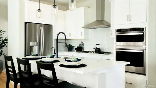 a kitchen with stainless steel appliances kitchen island granite countertop a table chairs stove and refrigerator
