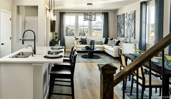 a view of a dining room and livingroom with furniture wooden floor a chandelier