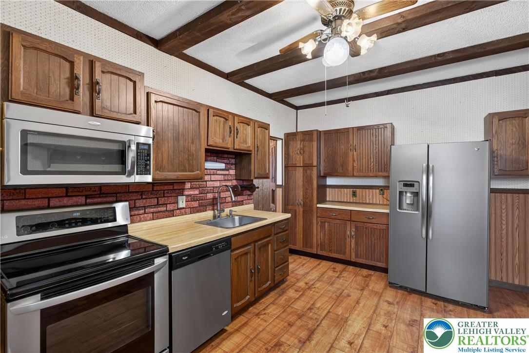 108 West 2nd Street Alburtis, PA 18011 - Photo 6 of 24 a kitchen with refrigerator cabinets and microwave