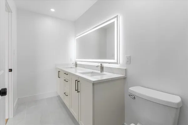 a bathroom with a sink a toilet and a mirror