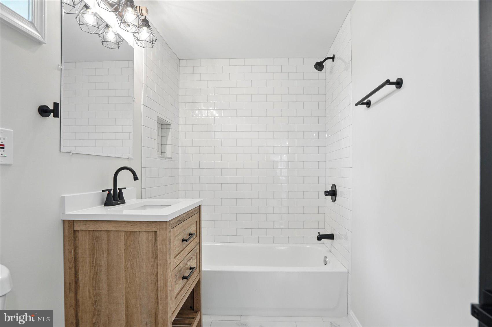 1504 Ameshire Road Lutherville-Timonium, MD 21093 - Photo 54 of 54 a bathroom with a bathtub a shower sink vanity and a mirror