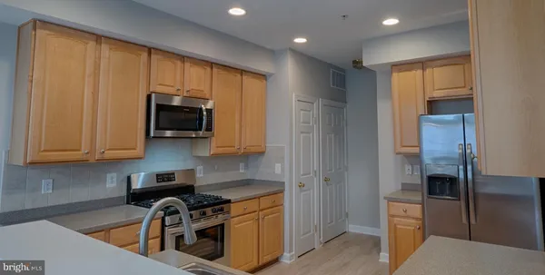 a kitchen with stainless steel appliances granite countertop a refrigerator and a stove top oven