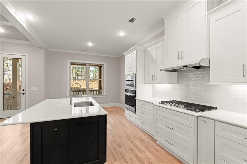 222 Trecastle Square, Unit 21 Canton, GA 30114 - Photo 8 of 45 a kitchen with stainless steel appliances a sink dishwasher stove and white cabinets with wooden floor