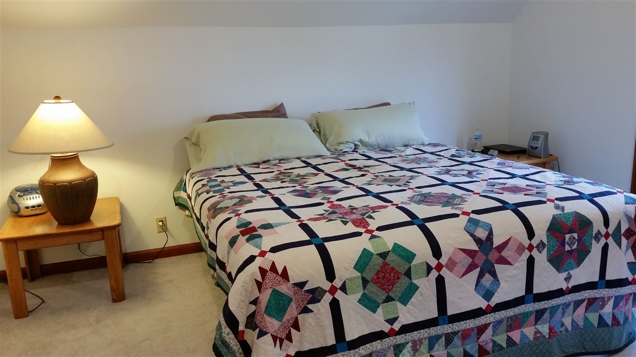 3112 East Holcomb Road Oregon, IL 61061 - Photo 16 of 25 a bedroom with a bed and a lamp on table