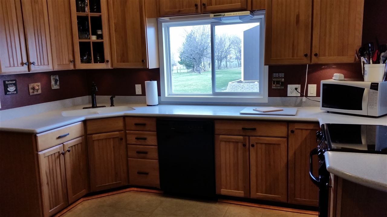 3112 East Holcomb Road Oregon, IL 61061 - Photo 7 of 25 a kitchen with stainless steel appliances granite countertop a stove a sink and a microwave